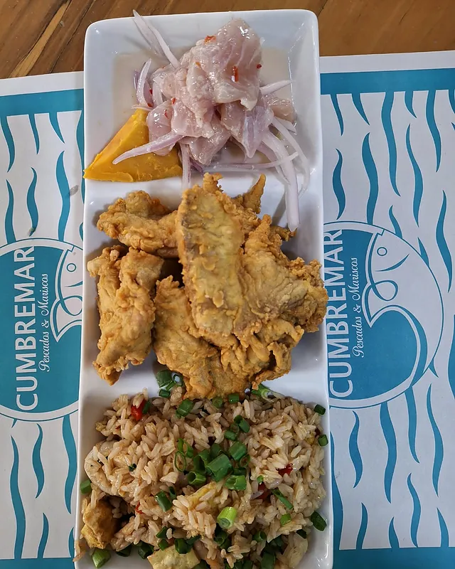 Un combinado con ceviche, chicharrón de pescado y arroz chaufa, sobre el individual de Cumbremar