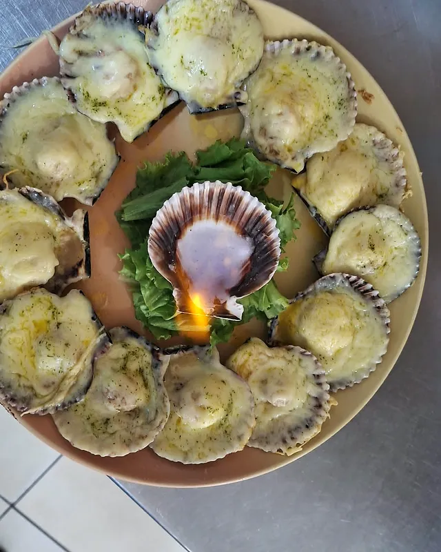 Conchitas a la parmesana en ronda, con una concha flameada al centro